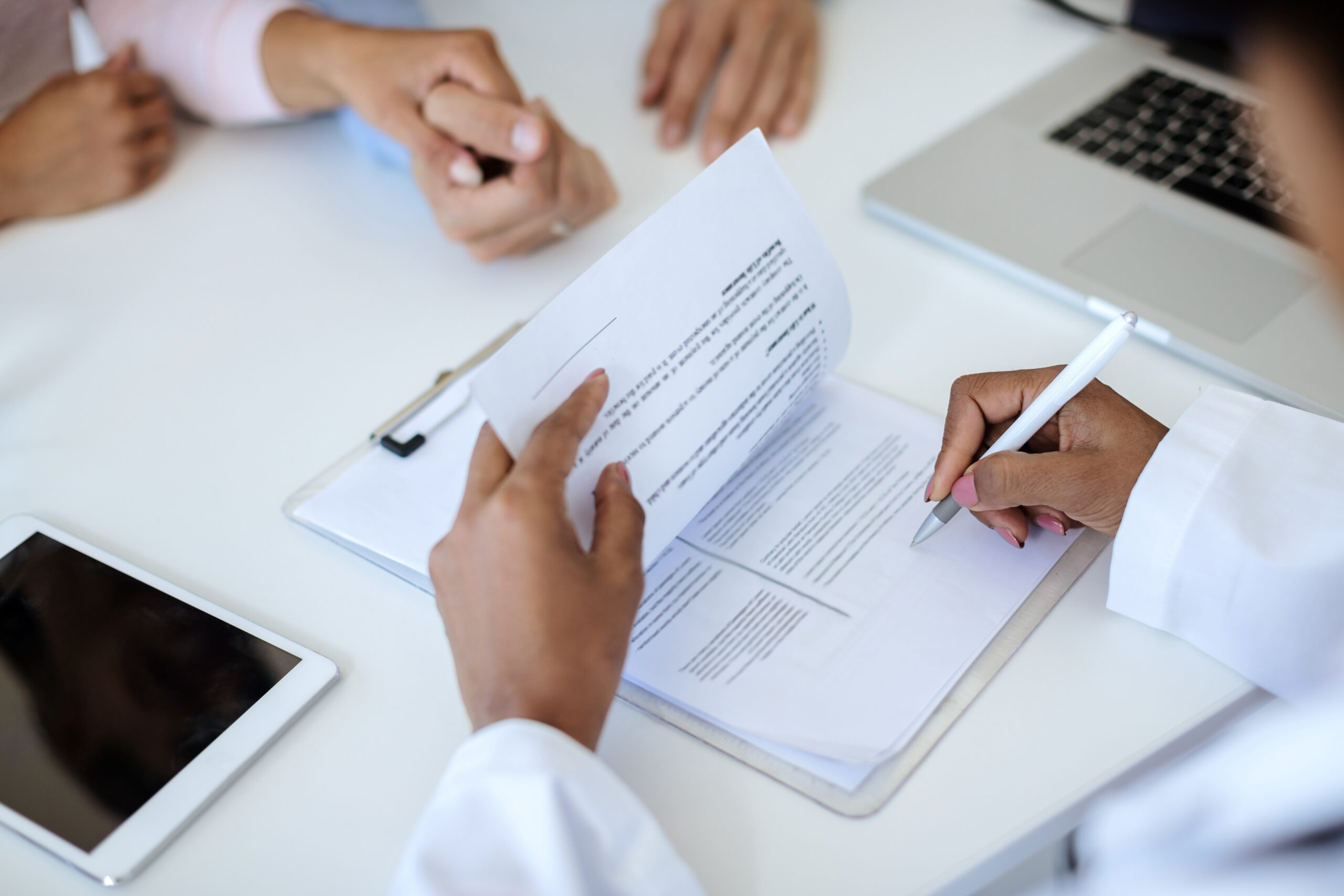 Close-up of female doctor signing medical reports.